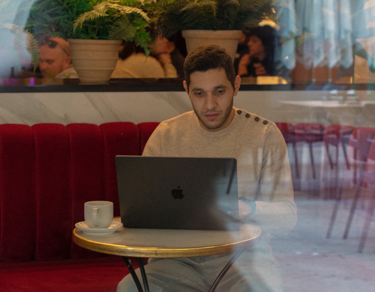 Mourad working on laptop in a cafe